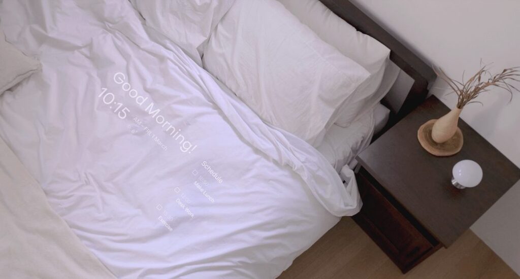Village displaying user's morning greeting and daily schedule projected onto a made bed