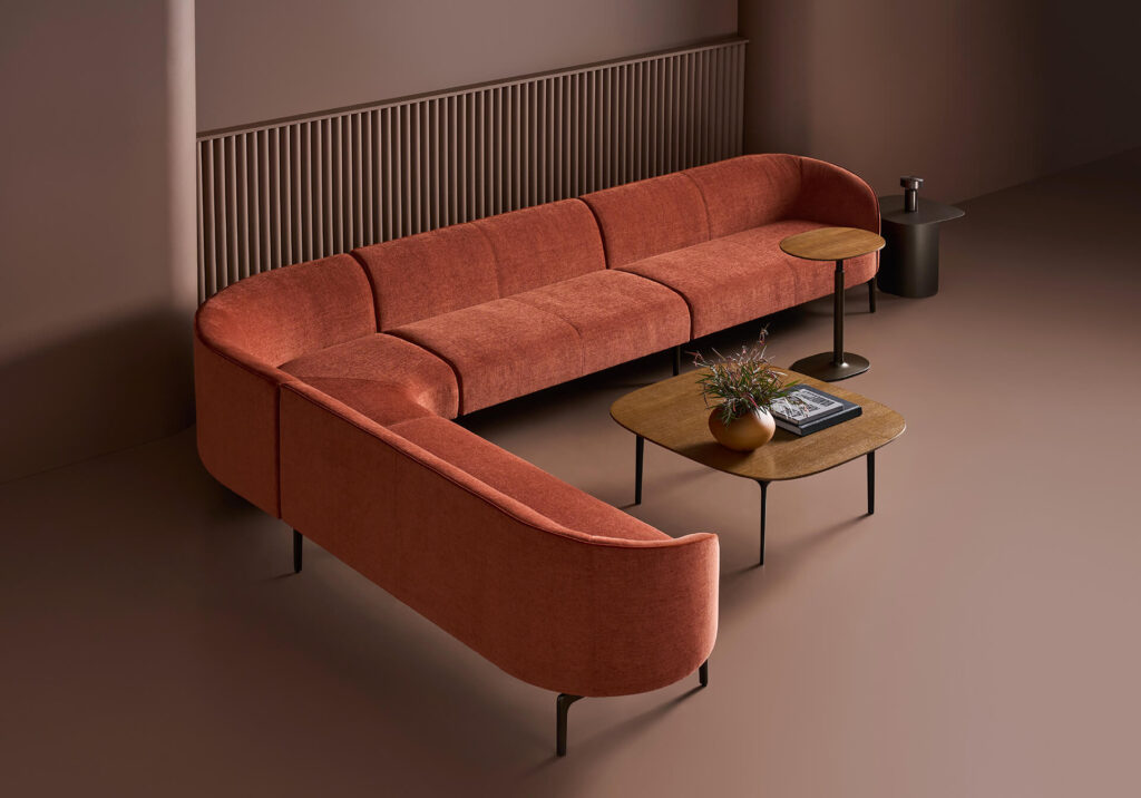 Rust/orange colored sofa view from above in room with brown floor and walls