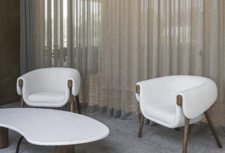 Two Monica chairs in white with white coffee table and sheer curtains
