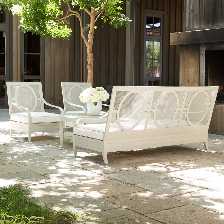 Sofa and two armchairs with table with flowers on top