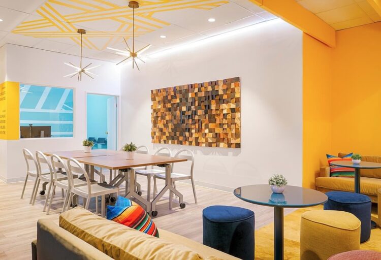 Reach L.A. interior with café table,, benching, yellow couch, and wood block art