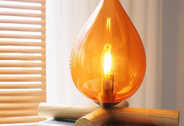 Campfire Table Lamp on stack of books with wood screen in background