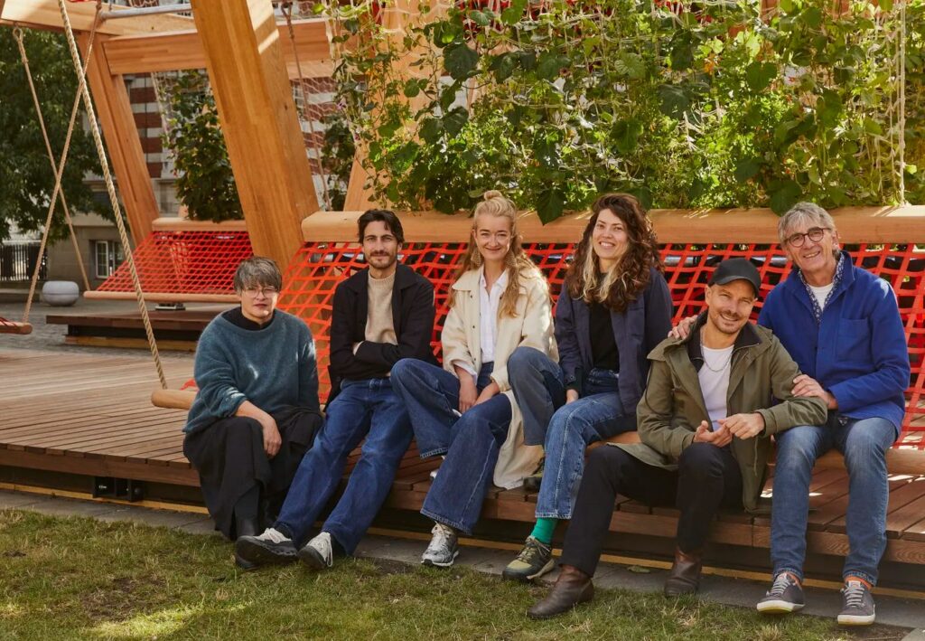 Vert team seated beneath climbing greenery