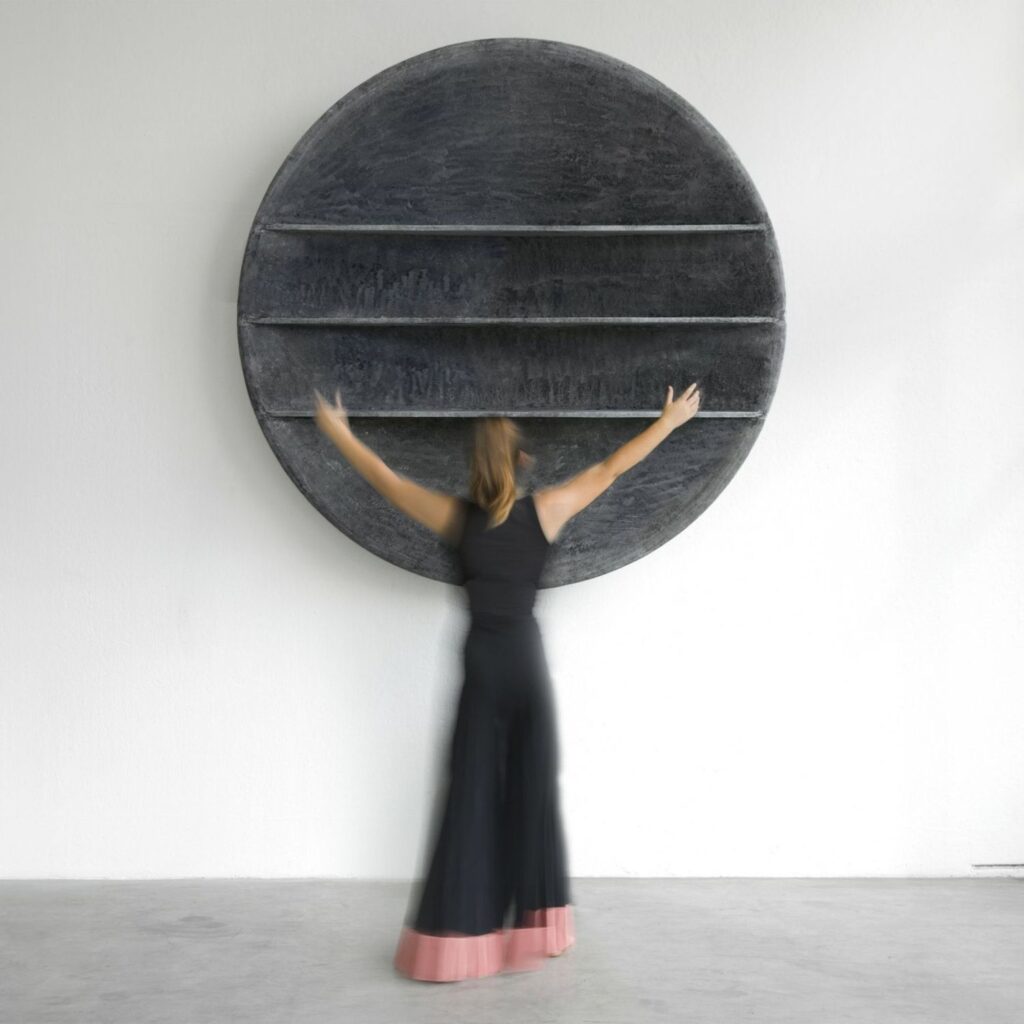 Aspis bookcase on wall with woman spreading arms