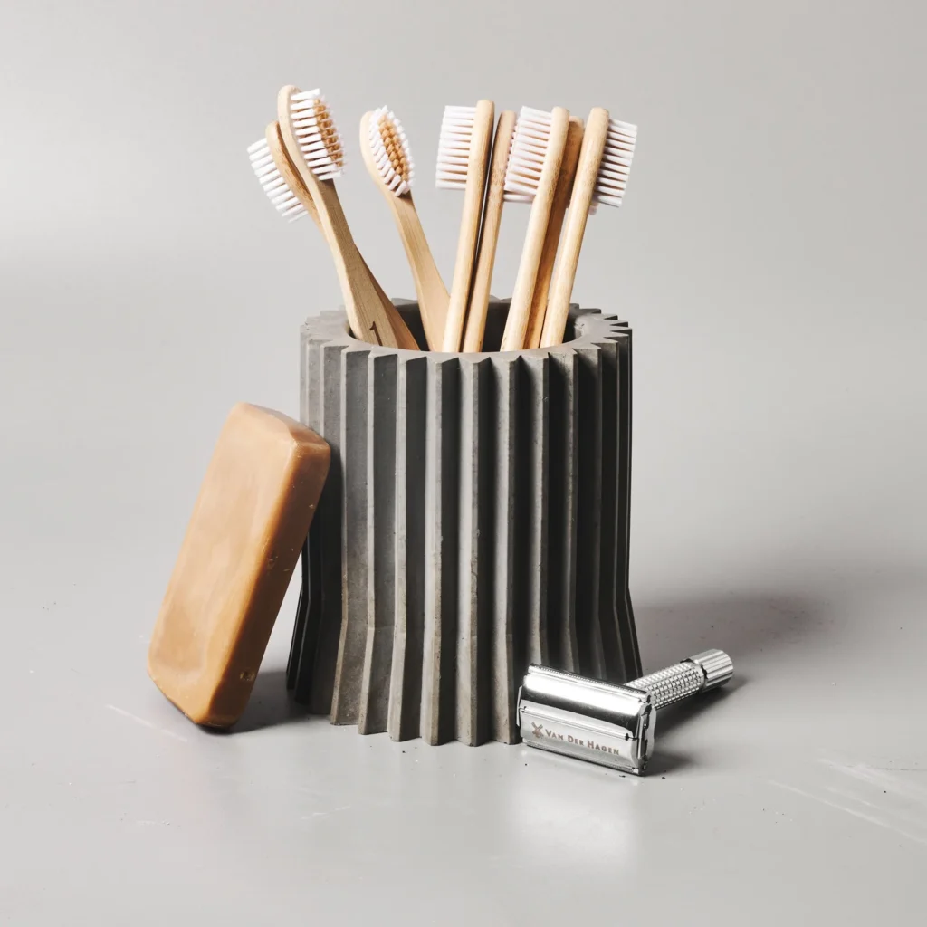 Concrete Toothbrush Holder with toothbrushes, soap, and a razor
