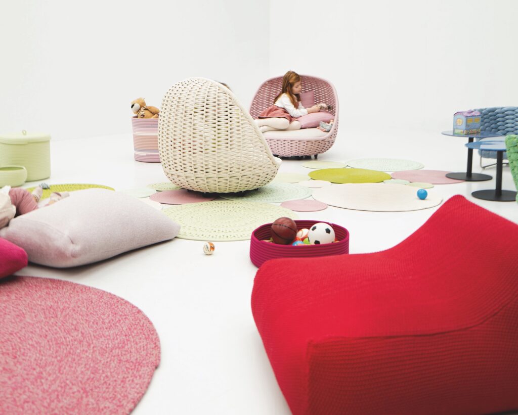 Paola Lenti Kids Collection girl in Orbitry Chair amid various pieces