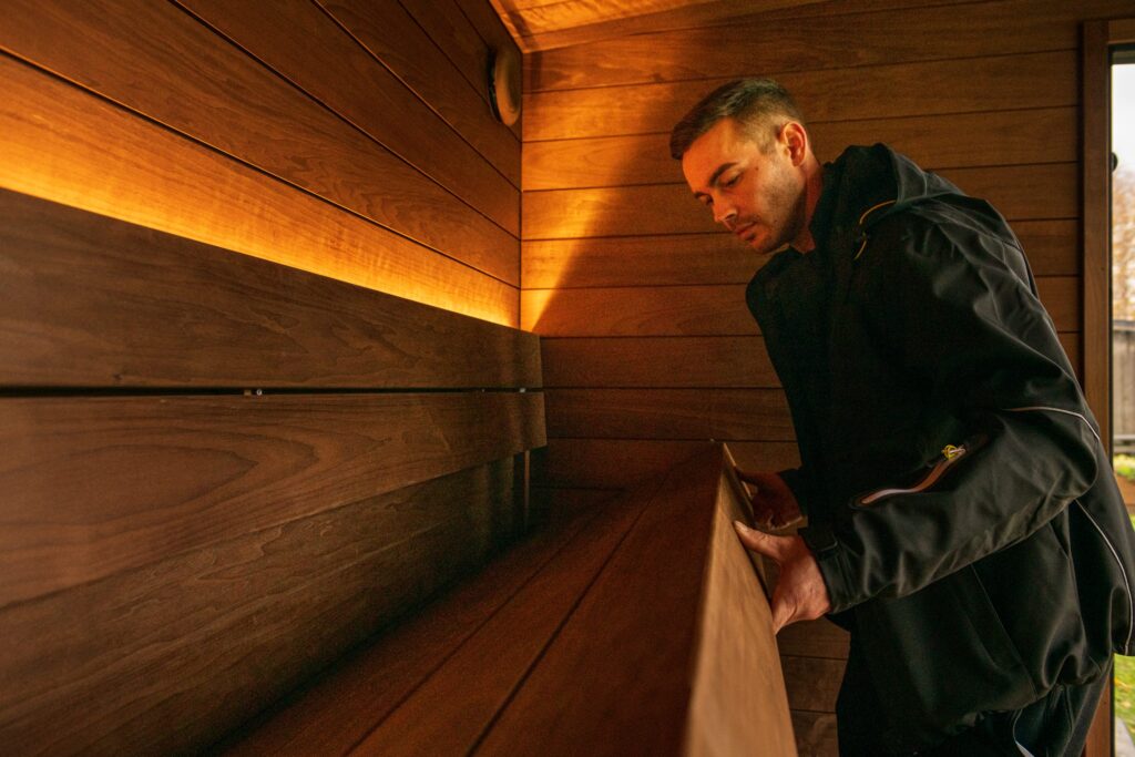 Man lifting sauna bench