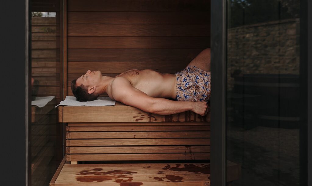 Man lying on bench in sauna