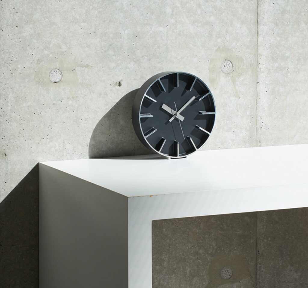 In black perched on table against cement wall