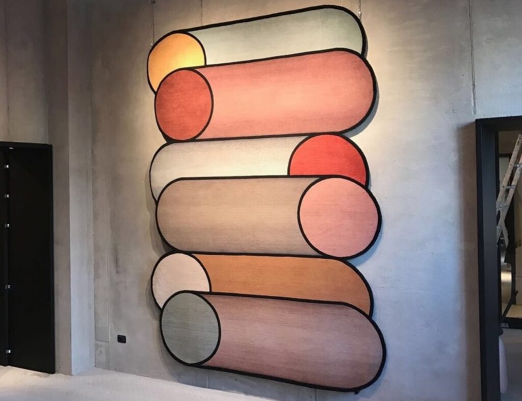 Urquiola-designed rug displayed on concrete wall