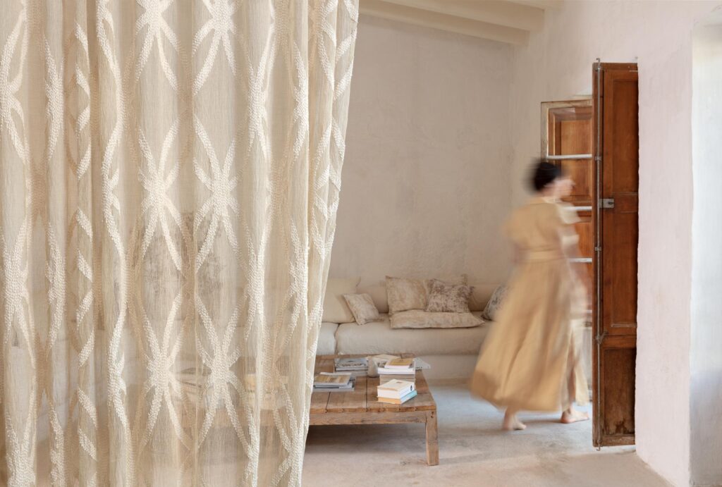 Sheer textile with star-like pattern in calming living room with woman leaving