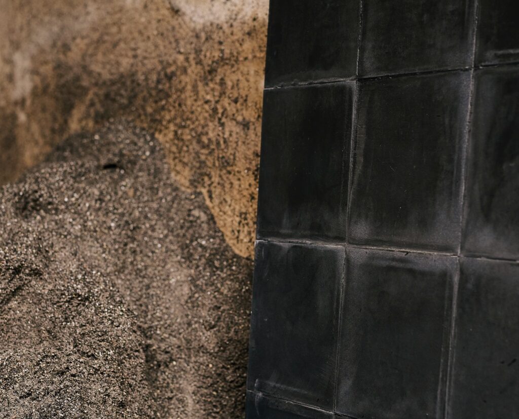 Black tiles joined together leaning on aggregate pile