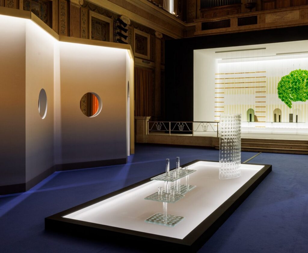 View of transparent sculptures with green glass bloom in background