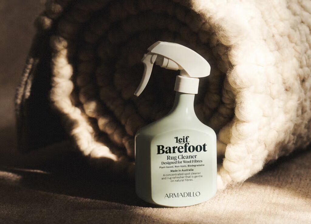 Lief Barefoot bottle in front of rolled rug