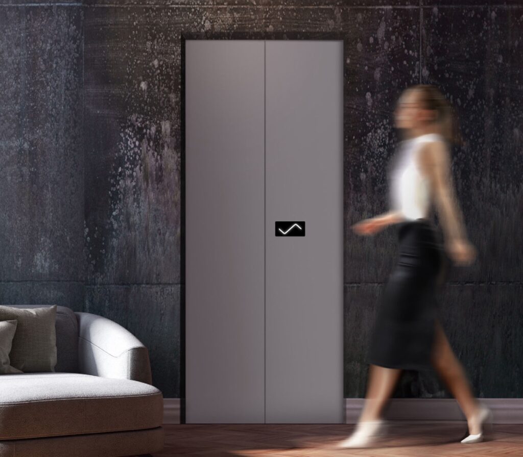 Elevator with gray doors and woman walking by
