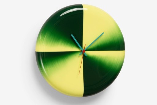 Round lacquered wall clock with bold yellow and green gradient quadrants, paired with thin blue and red hands. The glossy surface creates a reflective highlight. (lacquer wall clock)