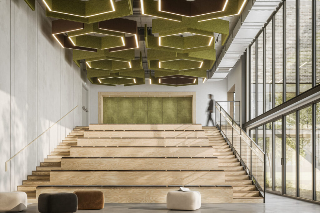 A stepped amphitheater-style workspace crowned by Sabin’s Linear Standard baffles in moss green, arranged in hexagonal clusters with glowing perimeter lines. The felt modules hover above pale wood risers and a double-height glass façade, softening sound while shaping the room’s strong vertical energy.