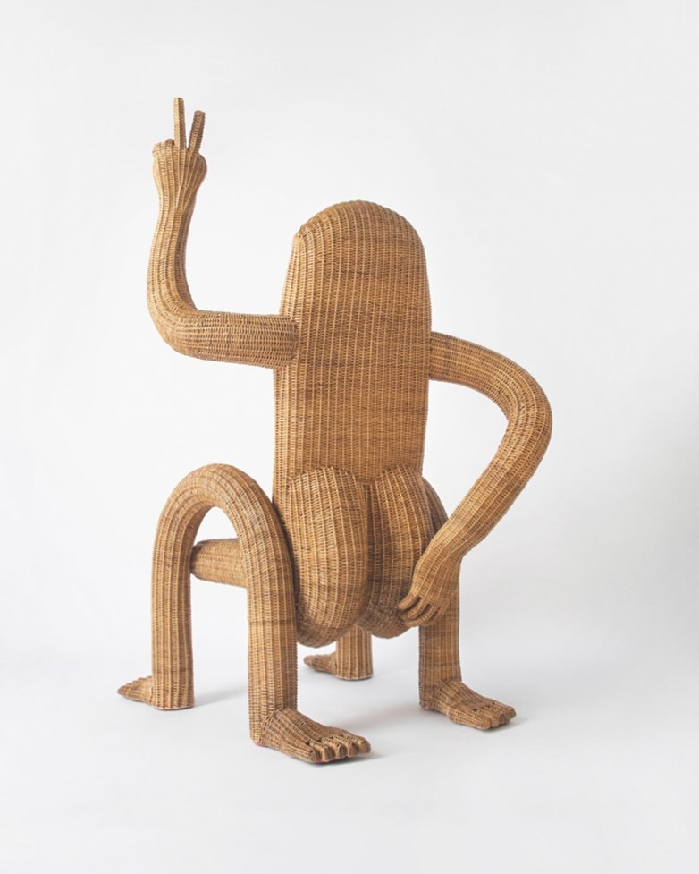 A woven rattan chair shaped like a seated figure captures whimsical furniture design through expressive form, sculptural posture, and hand-crafted texture.