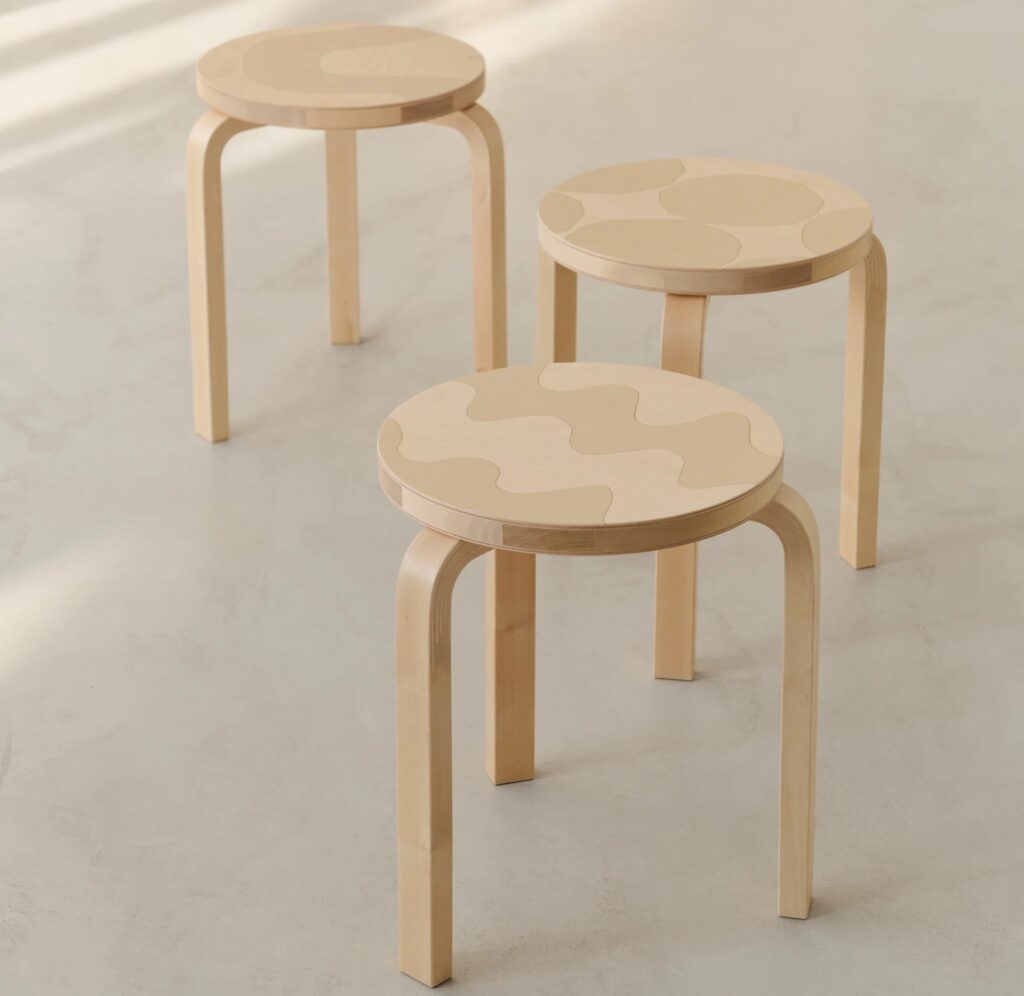 Aalto Stool 60 reimagined by Artek and Marimekko, featuring bent birch legs and a round seat inlaid with Maija Isola patterning rendered through tonal wood grain.