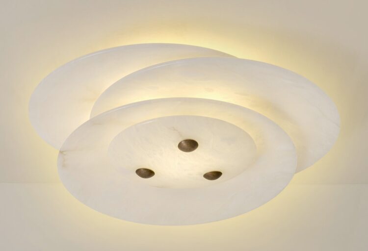 Asymmetric alabaster ceiling lighting shown from below, with staggered stone layers diffusing warm light in a calm, composed glow.