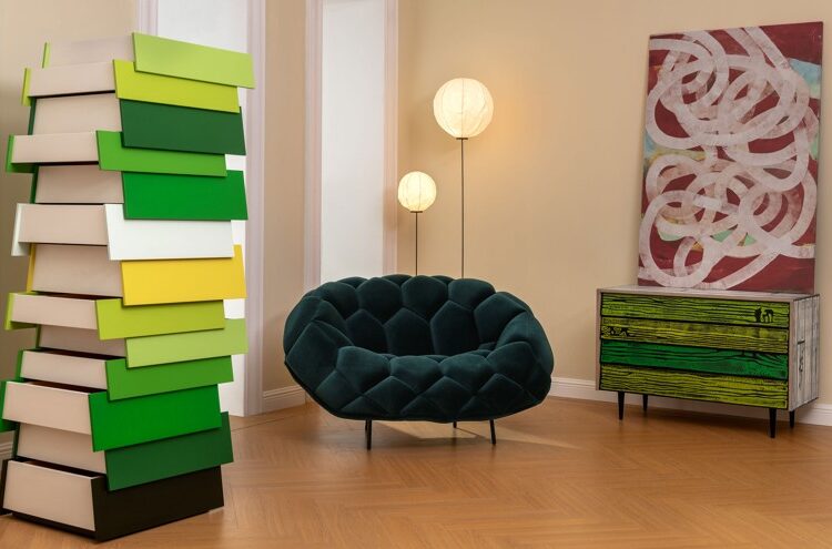 The Stack Storage Unit anchors a residential-style interior, its technicolor drawers adding visual energy beside lounge seating and art, demonstrating playful storage design as both functional furniture and visual punctuation.