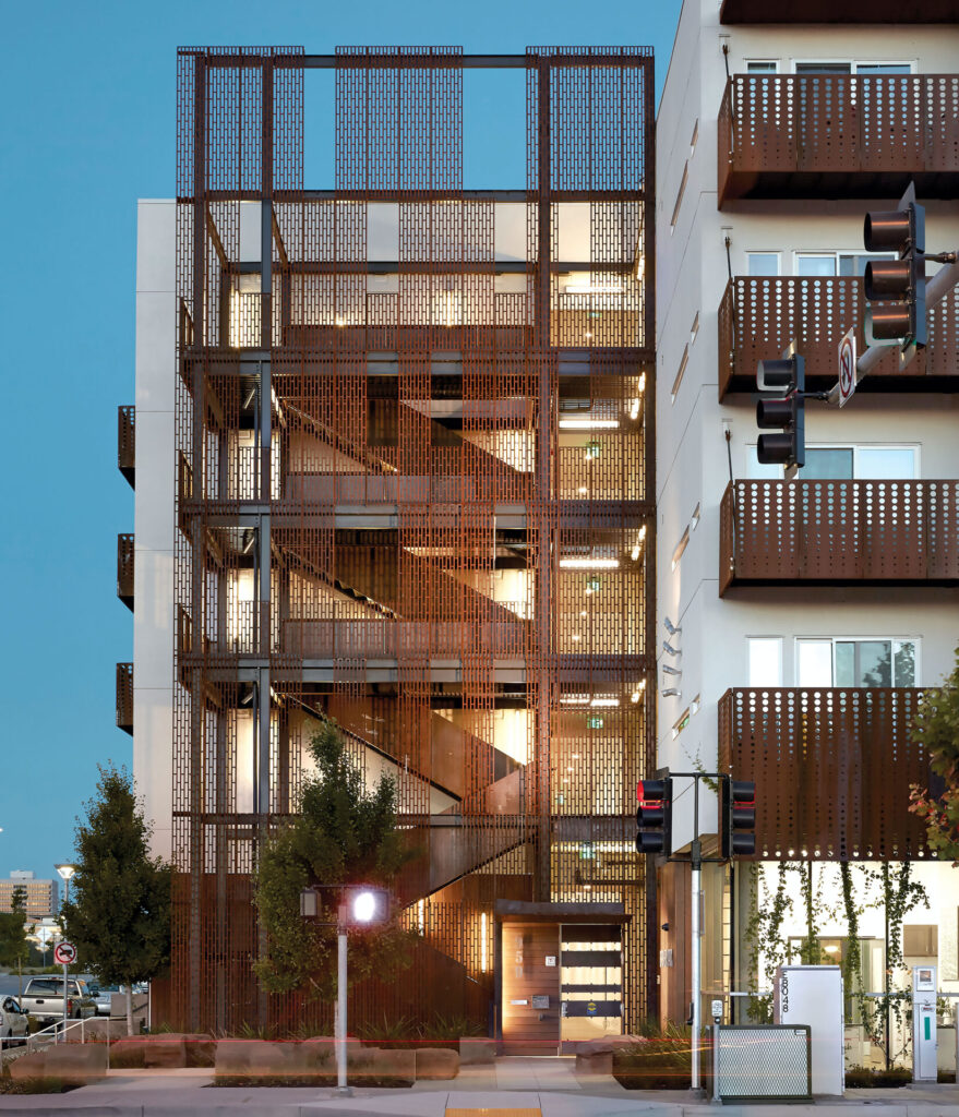 Exterior stair guardrail system in weathering steel wraps a multi-story stair tower, using perforated panels to balance transparency, safety, and architectural presence.