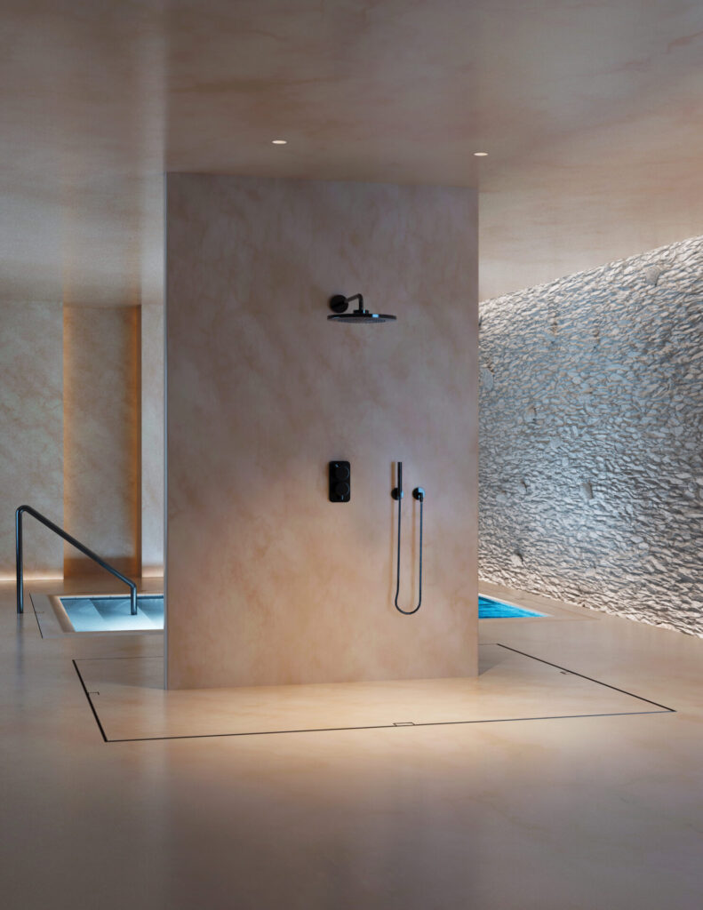 Wall-to-wall Site Sizable® slot drain creates a seamless line across a spa-style shower floor, demonstrating precision architectural drainage in large-format tile.