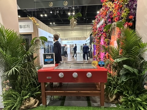 Outdoor kitchen vignette at KBIS 2026 featuring a red True Caliber grill and grilling station, highlighting performance-driven luxury appliances for exterior entertaining spaces.