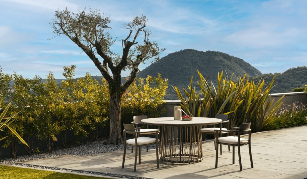 Detail view of the Lanai outdoor table collection, highlighting the contrast between sintered stone tabletop and woven rope base for durable, contemporary outdoor use.