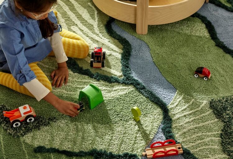 GREJSIMOJS high-pile rug in layered green tones, featuring a graphic, landscape-inspired pattern that adds softness and texture to a children’s play area or shared interior.