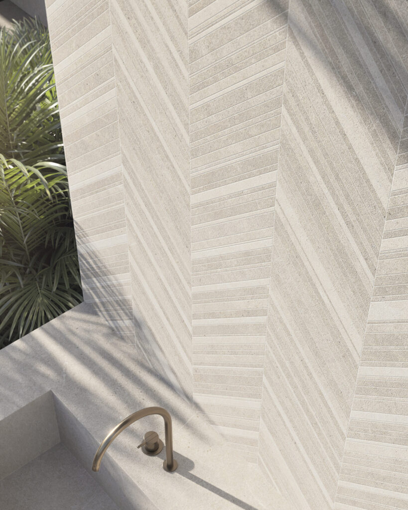 Sunlit outdoor bath in Mallorca Caliza large format porcelain slabs, where soft linear texture wraps walls in quiet, continuous relief.