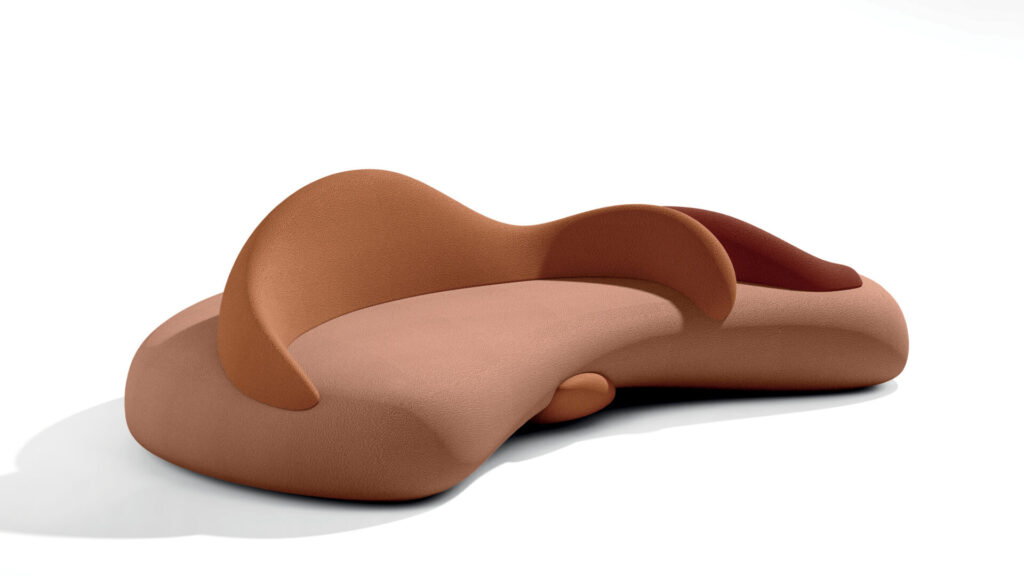 Sculptural outdoor seating by Ethimo in warm rust tones, Loop’s continuous upholstered form curves into a landscape-like lounge that invites circulation and relaxed gathering.