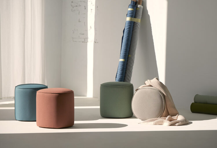 Colorful cylindrical poufs in recycled fabric, soft bathroom seating designed for comfort and quiet pause