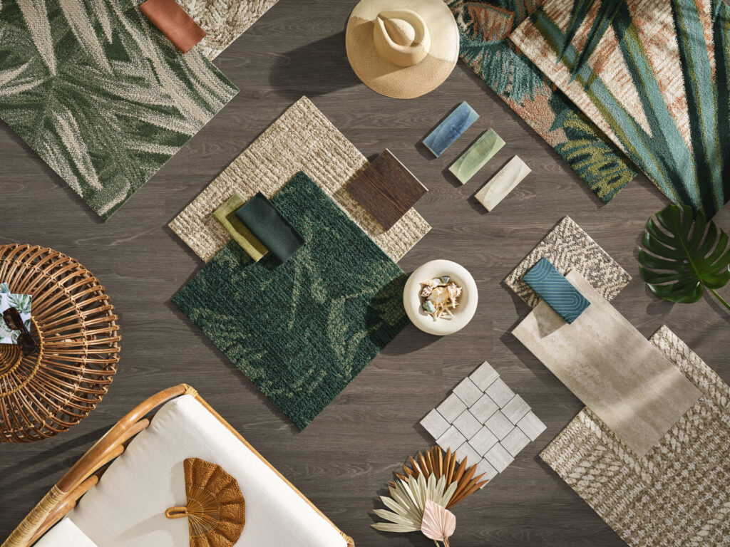 Hospitality flooring palette featuring tropical carpet samples in deep forest greens, woven textures, wood finishes, and coordinating LVT from Shaw Contract Hospitality ROAM Tropical Retreat collection.