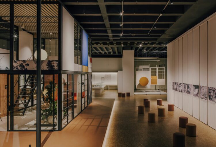 Interior view of the Eames Pavilion System with glass walls, mezzanine, and exhibition layout at Milan Design Week 2026