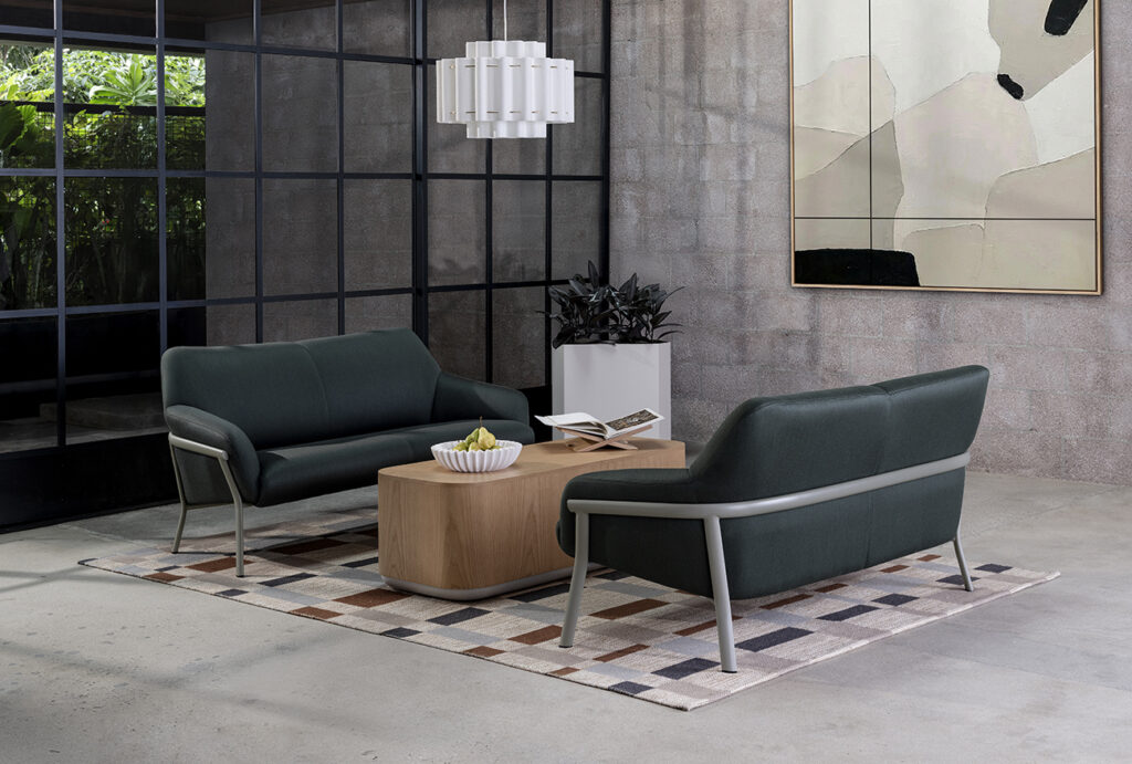 Talina loveseats by Arcadia in deep green arranged around a wood table, presenting contract lounge seating suited for hospitality and workplace lounges.