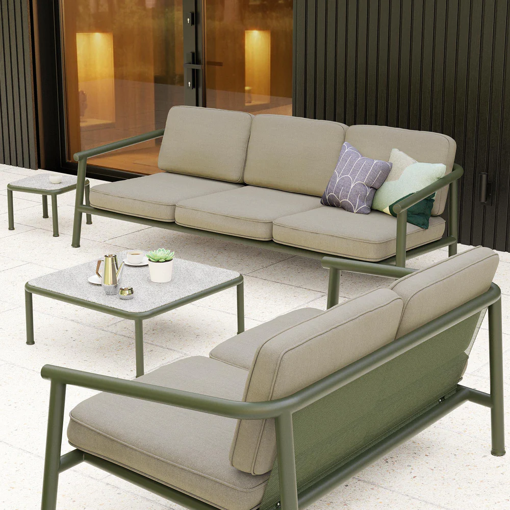 Bottle-green outdoor seating and low tables from Case Furniture create a relaxed hospitality terrace with deep cushions and architectural steel frames.