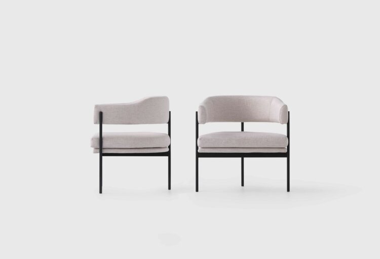 Two Isabella lounge seating chairs in soft neutral upholstery, front and back views highlighting curved backrest and delicate steel frame.