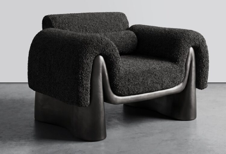 Black bouclé sculptural seating by Chris Shao for Movimento Gallery, featuring oversized draped armrests and a fluid dark metal base that curves around the seat.