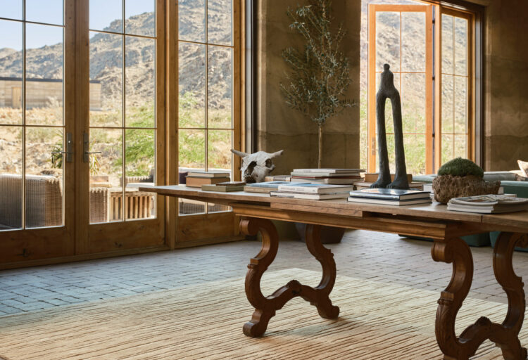 Tai Ping's Serene I Slate handcrafted wool and silk rug stretches beneath a carved wood table, its subtle linear texture reflecting the rocky Sierra Nevada landscape outside.