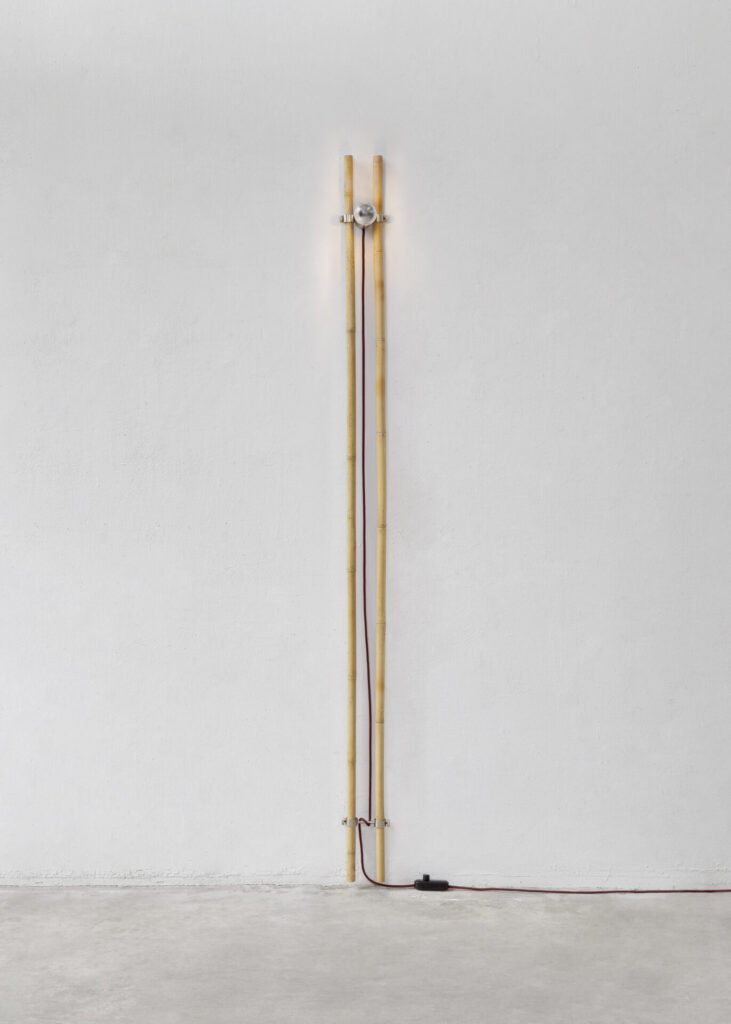 Bambù floor lamp by Gupica features two vertical bamboo poles joined by a brushed metal LED fixture, with an exposed red textile cord emphasizing the handcrafted bamboo lighting design.