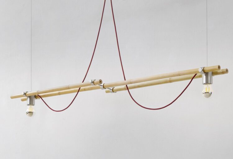 Bambù pendant bamboo lighting by Gupica suspends parallel bamboo canes with brushed metal fittings and exposed red cord loops, creating a minimalist collectible lighting fixture.