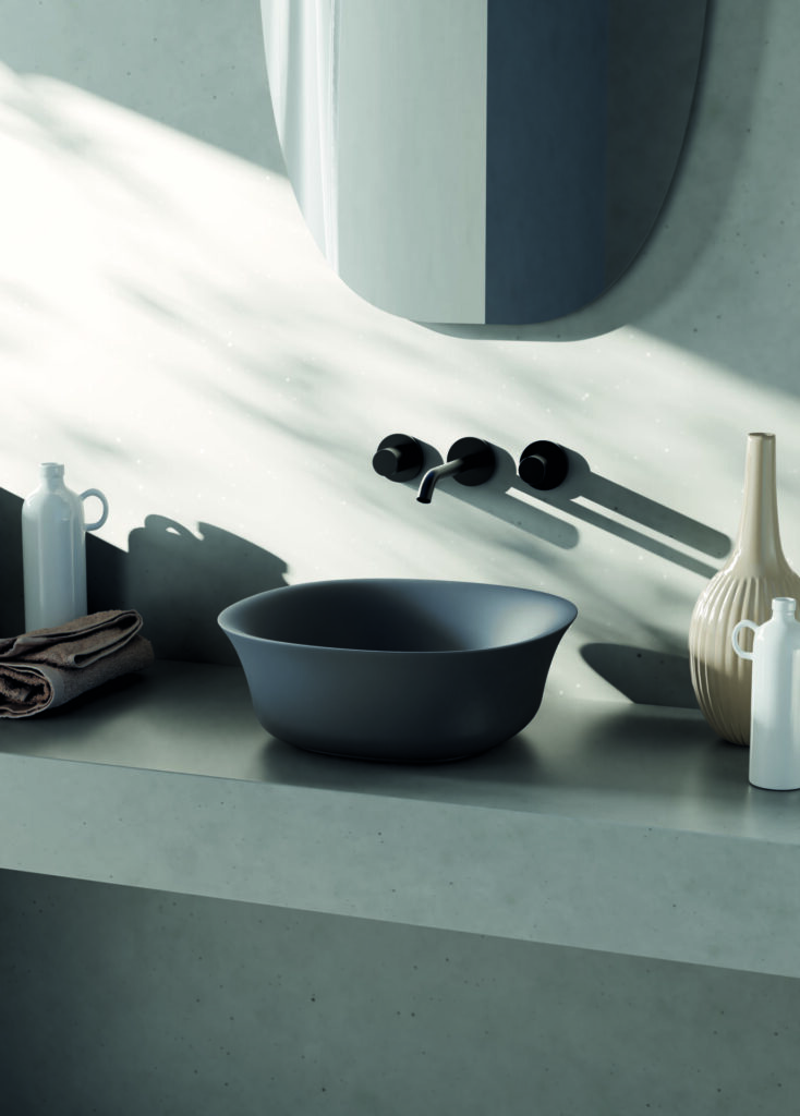 Italian ceramic vessel sink from Hastings Bath Collection's Flut family in matte black, featuring a sculptural flared rim and wall-mounted faucet.