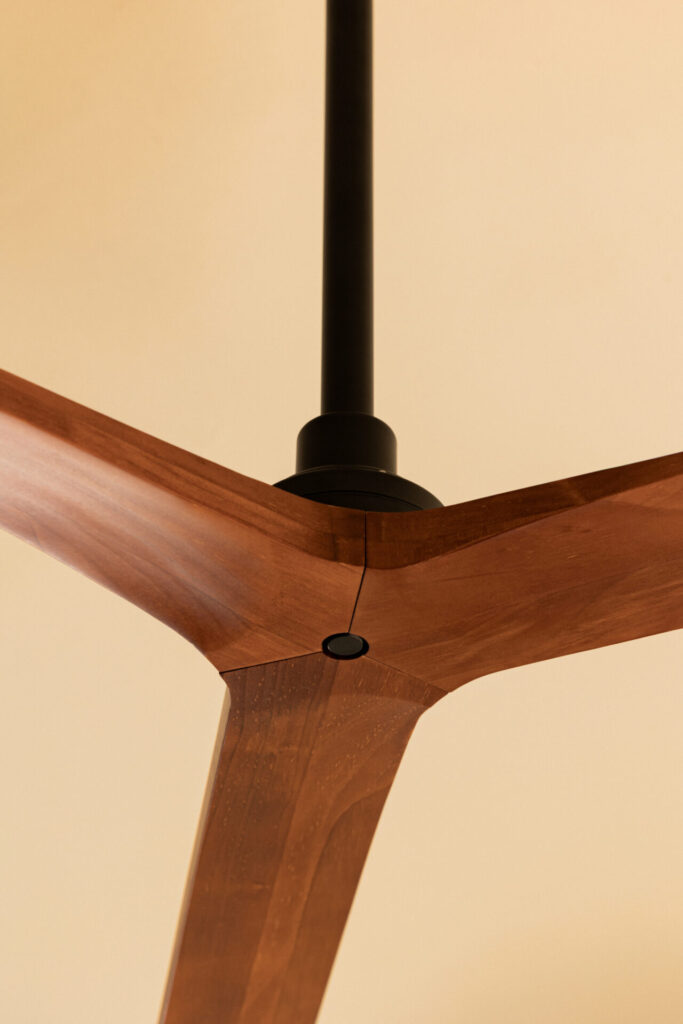 Faro Barcelona Klim architectural ceiling fan with dark walnut blades and matte black motor installed above a modern hospitality bedroom.