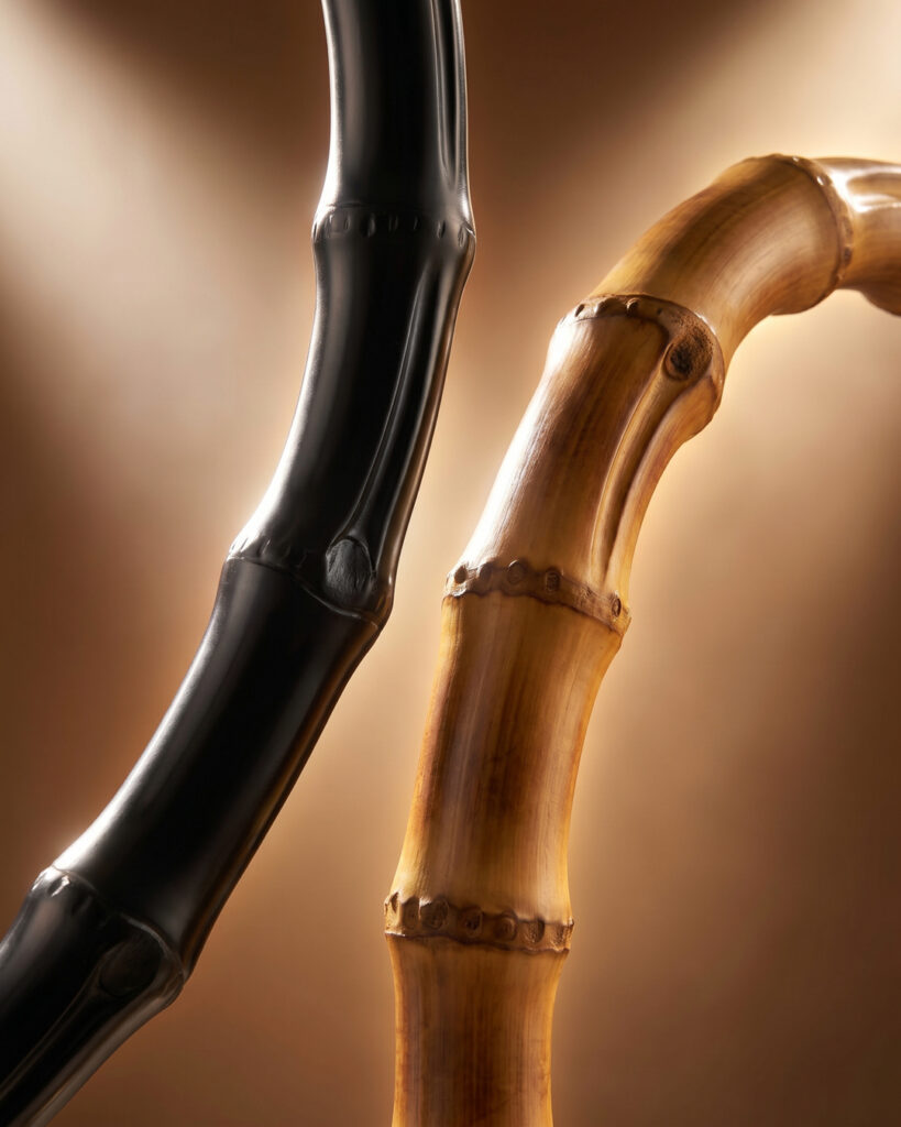 Two Gessi Jacqueline luxury bathroom fixtures faucets with handcrafted bamboo spouts in natural brass and matte black finishes.