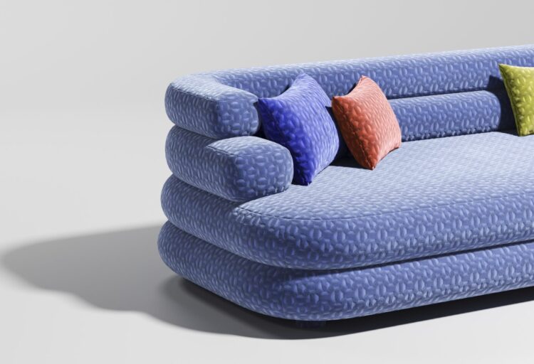 Blue upholstered sofa covered in Carnegie Crush commercial textiles with textured velvet and colorful accent pillows in a modern lounge setting.