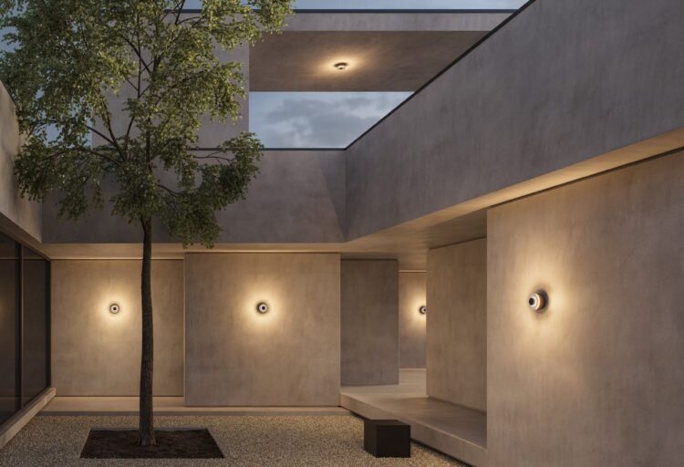 iGuzzini Cryso outdoor lighting creates soft radial illumination on courtyard walls with circular LED wall luminaires.