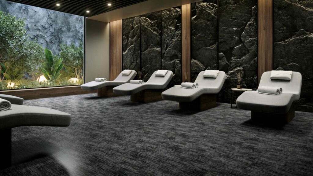 Roppe PixelArt Minimalist rubber flooring in a luxury spa lounge with charcoal tones beneath reclining chairs and stone walls.