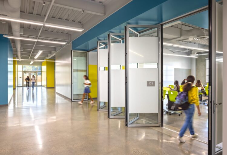 NanaWall NW Acoustical 645 folding acoustical glass walls partially opened along a school corridor