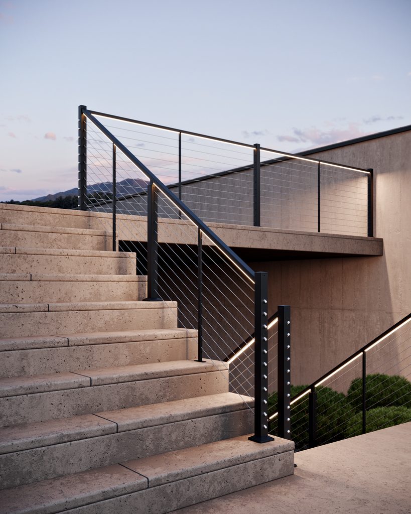 Feeney LED railing lighting integrated beneath a black DesignRail Modern top rail with horizontal cable infill at dusk.